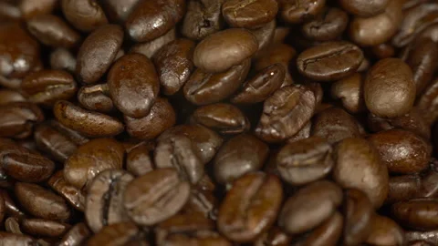 Close up of fresh coffee beans rotating on a platter Stock Footage 232081309