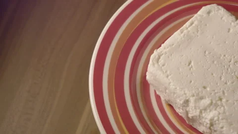 Close-up of fresh cottage cheese on a red platter indoors. 스톡 동영상 135214035