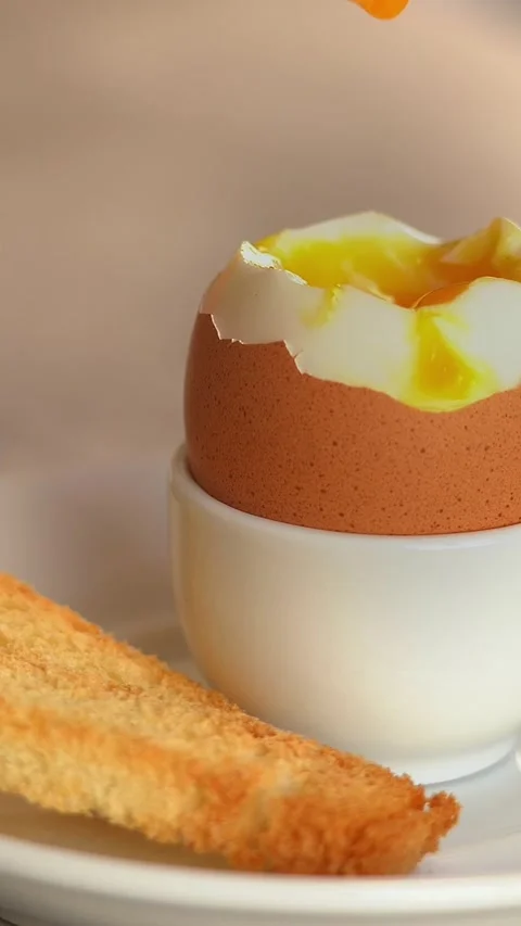 Close up of fresh crispy bread crouton dips in soft-boiled egg. Breakfast Stock Footage 302277866