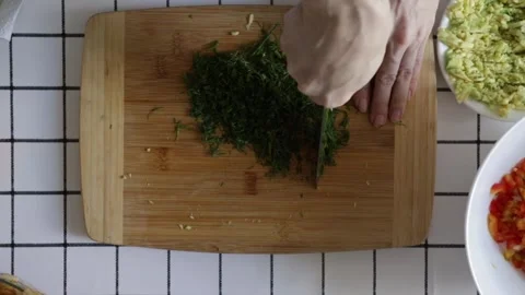 Close-up of fresh dill being chopped on a wooden cutting board during meal .. Stock Footage 315517829