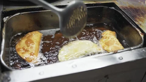 Close up of fresh empanadas frying in boiling oil. Cooking process of national Stock Footage 270236167