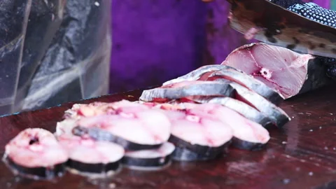 A close-up of fresh fish being expertly sliced into steaks on a cutting board. Stock Footage 292348448