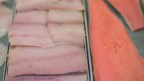Close-up of fresh fish fillets, including white fish and salmon, on display in a 動画素材 277617049