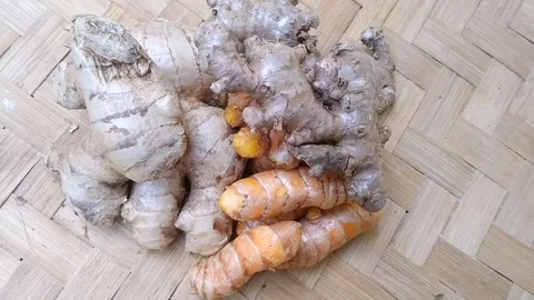 Close Up of Fresh Ginger Red Ginger and Whole Turmeric on Bamboo Mat Stock Footage 340538138
