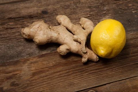 Close up of fresh ginger root spice and lemon on wooden table Stock Photos