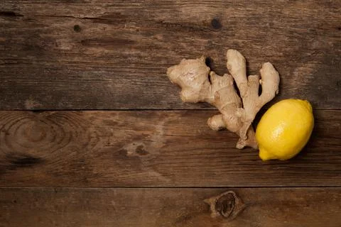 Close up of fresh ginger root spice and lemon on wooden table Stock Photos