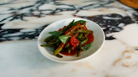 Close up of a fresh gourmet mixed green salad with tomatoes and dressing served Stock Footage 336849623