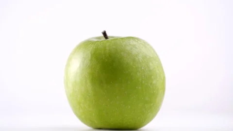 Close-up of fresh green apple rotating on white background in 4K resolution Stock Footage 129068987