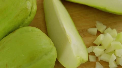 Close up of fresh green whole and sliced chayote squash on a wooden cutting boar Stock Footage 346644448