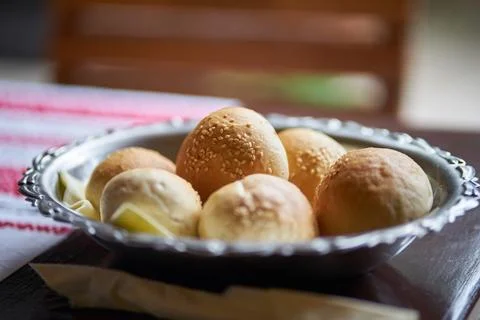 Close-up of fresh homemade bread rolls served in a metal bowl on wooden table 写真素材