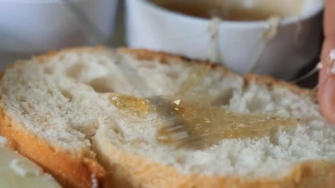 Close up of fresh honey spread on a bread Stock Footage 273128516