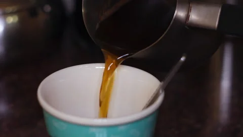 Close-Up of Fresh Hot Coffee Being Poured into a Colorful Decorative Cup Stock Footage 337428898