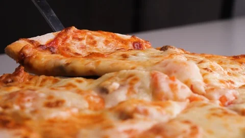 Close up fresh hot pizza slices with melting cheese being scooped Stock Footage 125982034