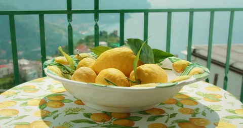 Close-up of fresh lemons in a ceramic bowl on a table overlooking the Amalfi Stock Footage 306758641