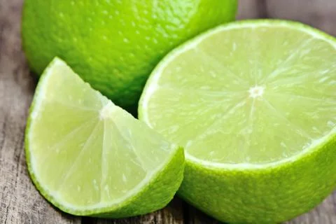 Close up of fresh lime green on a rustic table Stock Photos
