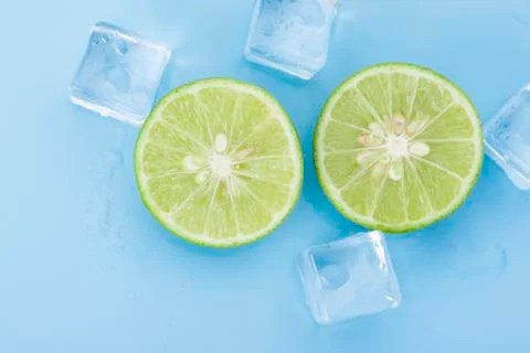 Close up fresh lime with ice cube on blue Stock Photos