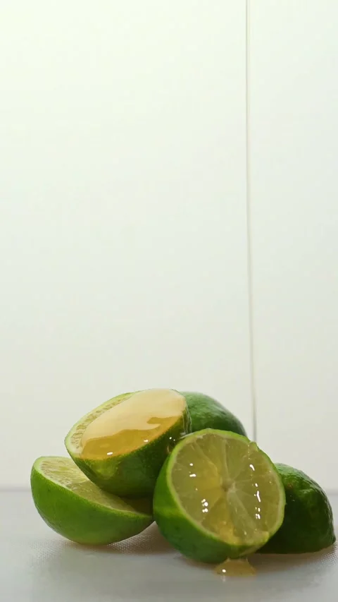 Close-up of fresh lime slices in bright studio lighting with honey being Stock Footage 330377754