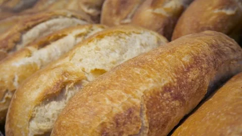 Close up of fresh loaf or bread rolls lying in a row. Stock Footage 296339343