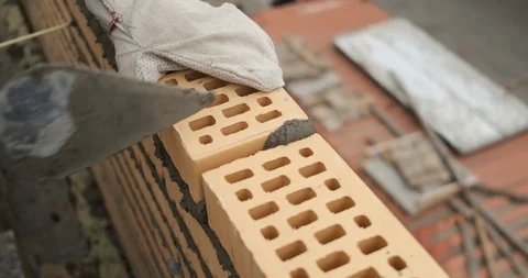 Close-up of fresh masonry, bricklayer puts brick into masonry wall, professional Stock Footage 117088265