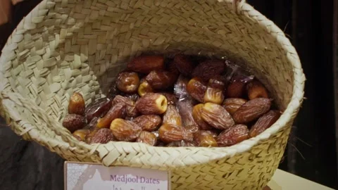 Close-up of fresh Medjool dates piled inside a traditional woven basket at Stock Footage 333537843
