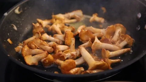 Close-up of fresh mushrooms getting cooked in frying pan Stock Footage 114846627