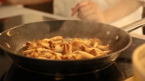 Close-up of fresh mushrooms getting cooked in frying pan Stock Footage 114846628