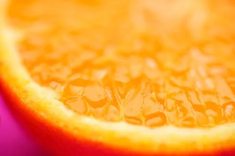 Close up of fresh orange fruit texture on vibrant pink background Stock Photos