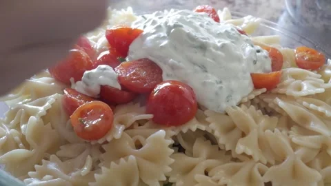 Close-up of a fresh pasta salad with cherry tomatoes and creamy dressing being Vidéo 303481526
