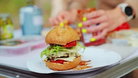Close Up of Fresh Picnic Burger Being Prepared Outdoors by Female Cook Stock Footage 315077170
