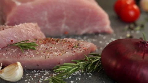 Close up of fresh pork is sprinkled with pepper, spices and seasonings Stock Footage 150085149