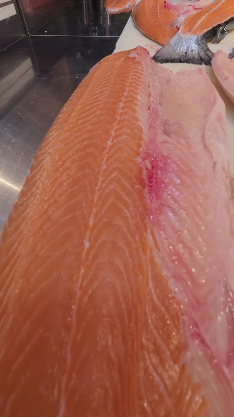 Close-up of fresh raw salmon fillet on a cutting board in a professional kitchen Stock Footage 314446053