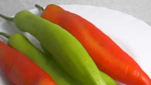 Close-up of fresh red and green pointed chili peppers rotating on a white p.. Stock Footage 340070219