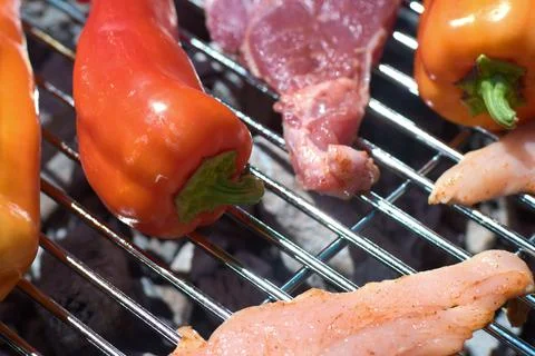 Close-up of fresh red and orange bell peppers grilling on a hot barbecue grat Stock Photos
