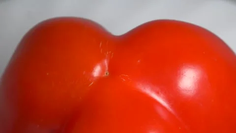 Close-up of a fresh red bell pepper rotating on a white plate, showcasing i.. Stock Footage 340073896