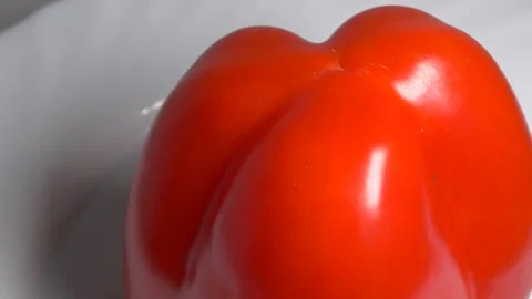 Close-up of a fresh red bell pepper rotating on a white plate, showcasing i.. Stock Footage 340073908