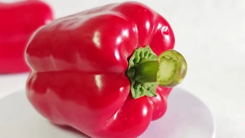 Close-up of fresh red bell pepper with green stem on white background. Stock Footage 340937778