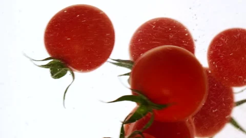 Close-up fresh red cherry tomatoes moving and splashing in water in slow motion Stock Footage 319978222