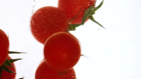 Close-up fresh red cherry tomatoes moving and splashing in water in slow motion Stock Footage 321585316