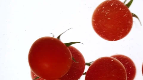 Close-up fresh red cherry tomatoes moving and splashing in water in slow motion Stock Footage 321995478