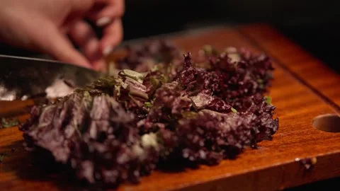 Close Up of Fresh Red Leaf Lettuce Being Chopped on Wooden Cutting Board Stock Footage 336466910