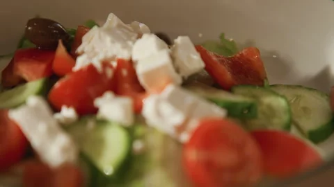 Close up of fresh salad ingredients including tomatoes cucumbers olives and feta Stock Footage 344869010