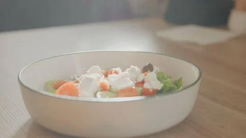 Close up of fresh salad with vegetables cheese in white ceramic bowl on wooden Stock Footage 344868884