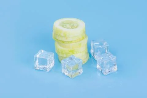 Close up fresh slice cucumber with ice cube on blue Stock Photos