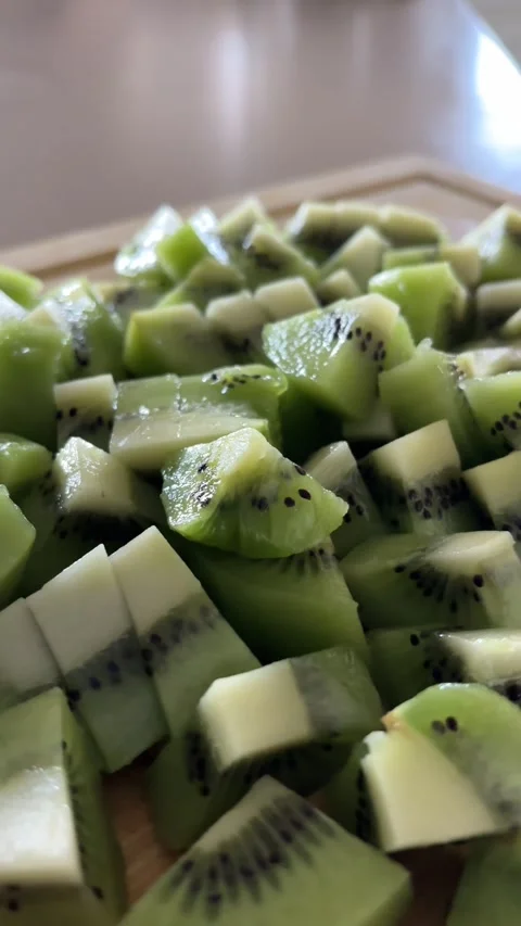 Close-Up of Fresh Sliced Kiwi Fruit on Wooden Cutting Board Stock Footage 337848931