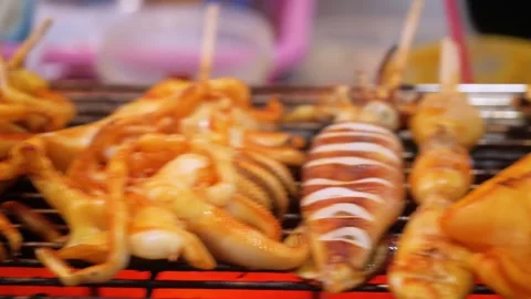 Close Up of Fresh Squid and Sea Snails Grilling on a Hot Charcoal BBQ Grill at a Stock-Footage 344218231