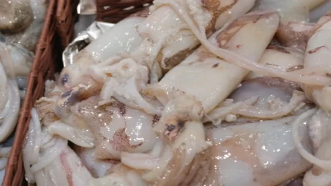 Close-up of fresh squid with speckled skin on ice at a seafood market, Cote Stock Footage 344800205