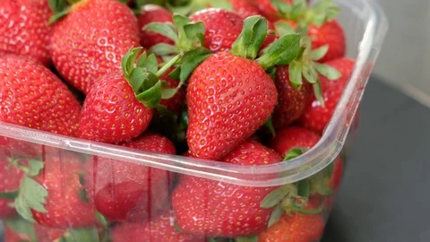 Close up of fresh strawberries in plastic box on 360 degree rotating stand, Video stock 127862792