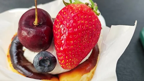 Close-up of fresh strawberry, cherry, and blueberry toppings on a dessert. Stockbeeldmateriaal 339780336