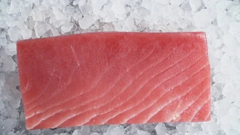 Close-up fresh tuna fish on chipped ice top view, cooking in slow motion 動画素材 106956397