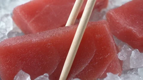 Close-up fresh tuna fish on chipped ice top view, cooking in slow motion Video stock 106956406